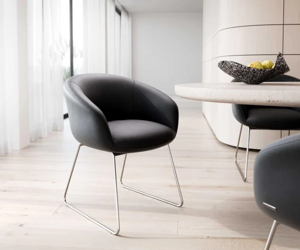 Chaise-de-salle-à-manger Vinka-Flex avec accoudoirs cuir de vache noir pied trapèze acier inoxydable brossé ressorts ensachés